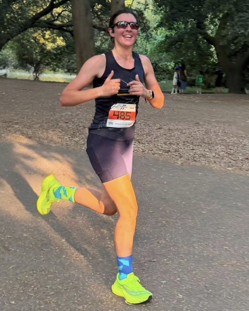 Lauren Bradford running a race, smiling, wearing a race number